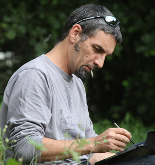 Yann Le Bris dessinant sur le terrain avec une tablette tactile