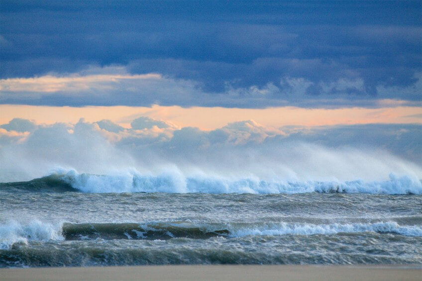 Les vagues formées par le mistral s'écrasent sur la plage. Balade en Camargue dans le vent et les pieds dans l'eau