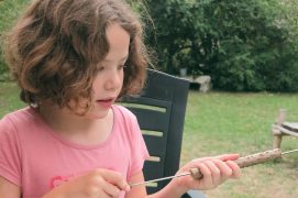 Coupez un morceau de branche de sureau d’un diamètre extérieur d’environ 2 cm. Faites coulisser la pique pour expulser la mousse blanche. Une fois évidé, son diamètre intérieur doit pouvoir laisser passer une boule.