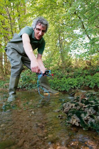 Pascal Stucki mesure la température de l’eau, une valeur fatidique pour les larves d’insectes. / © Gilbert Hayoz