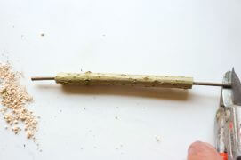 Introduisez une petite branche à l’intérieur qui dépasse de 10 cm : ce sera le poussoir. Son diamètre devra lui permettre de coulisser facilement dans votre tuyau.