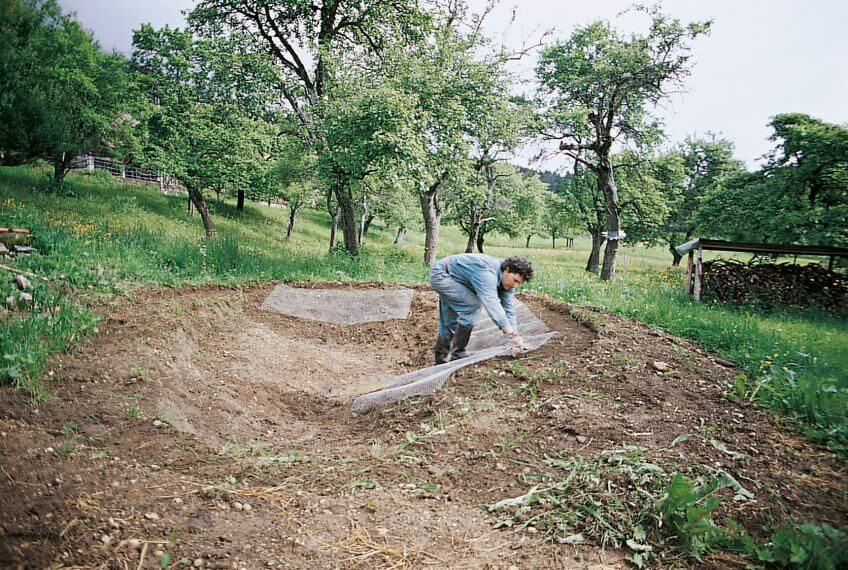 Pose d'un treillis pour protéger la bâche des rongeurs. treillis pour protéger la bâche des rongeurs 1998 mare étang