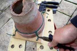 Entourez le rebord du pot de fleur d’un fil de fer puis fixez-le aux quatre clous de la planchette toujours à l’aide de fil de fer mais aussi d’une pince. Ensuite, il n’y a plus qu’à installer le nichoir.