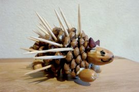 Dessinez les yeux et la bouche. Puis insérez un minimum de 25 cure-dents en les répartissant sur le haut et les côtés du hérisson. Mettez un point de colle au bout de chaque piquant avant de le coincer entre les écailles.