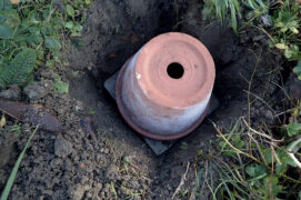 Positionnez une planchette sur le pot et placez le tout retourné dans le trou.