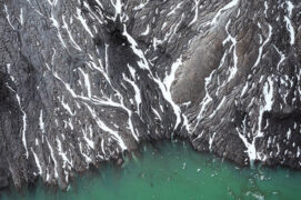 Avant de rejoindre ce lac de barrage émeraude, l’eau s’est écoulée sur la paroi de la montagne et a creusé des sillons dans lesquels la neige se réfugie. Avant de rejoindre ce lac de barrage émeraude, l’eau s’est écoulée sur la paroi de la montagne et a creusé des sillons dans lesquels la neige se réfugie. / © Pierre Jeanneret